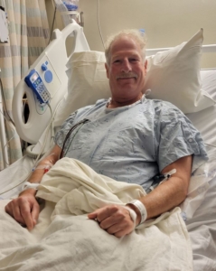 Man lying in hospital bed smiling