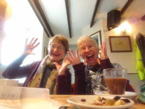 Two women sitting at a restaurant table laughing