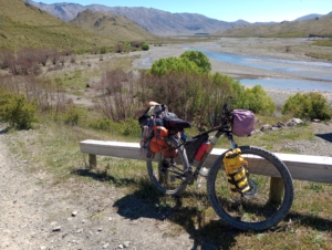 Loaded touring bicycle in front of a lake and mountains