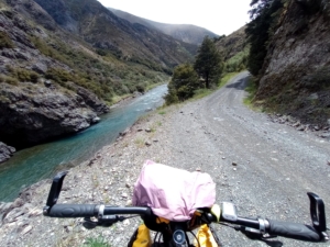View from the front of bicycle handle bars of an empty mountain trail and stream