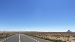 An empty paved highway running through the desert.