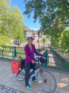 Woman posing on a loaded touring bicycle on a bridge