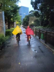 man and woman riding bicycles in the rain